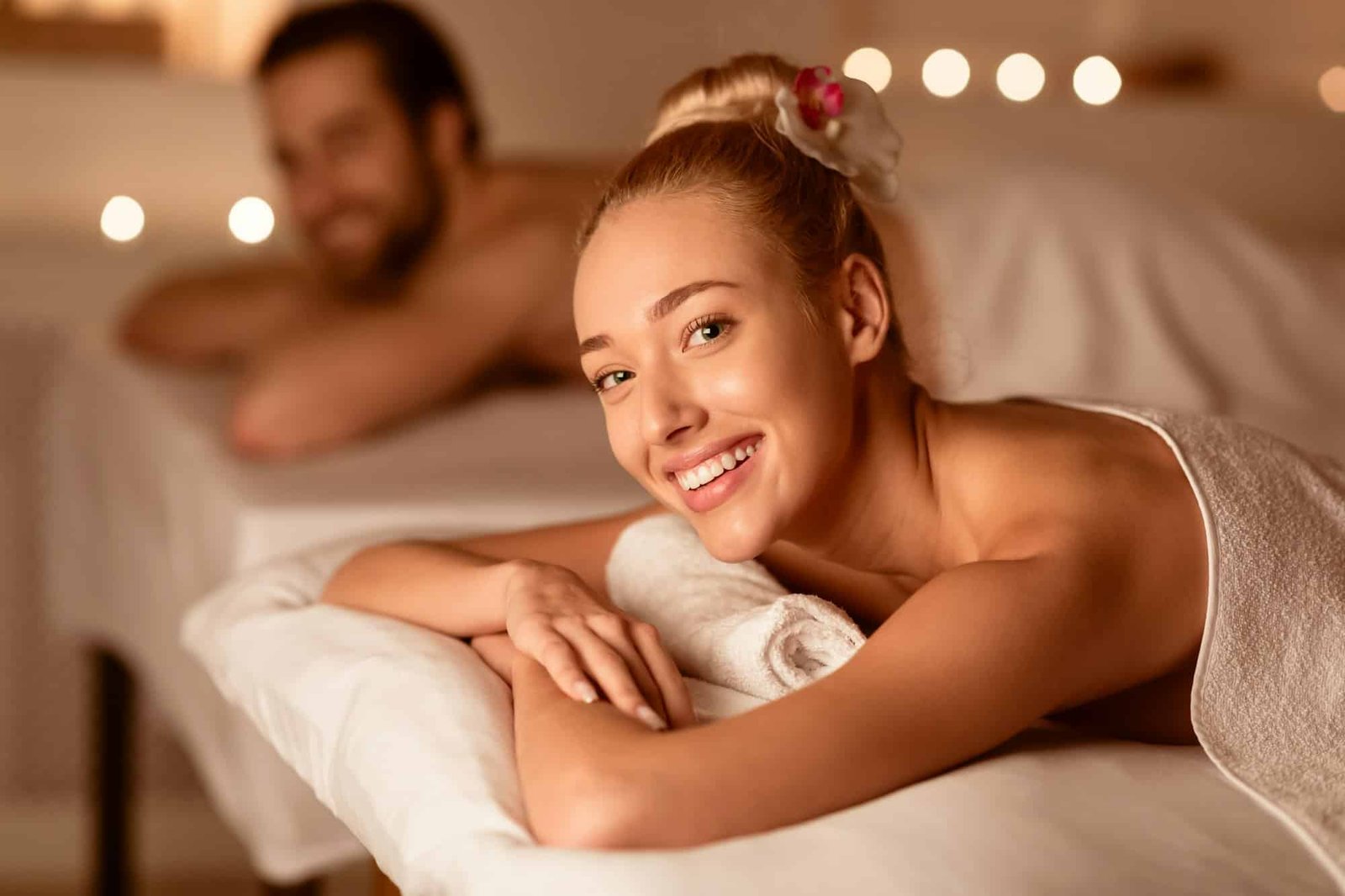 Woman At Couples Massage Smiling Lying On Bed At Spa